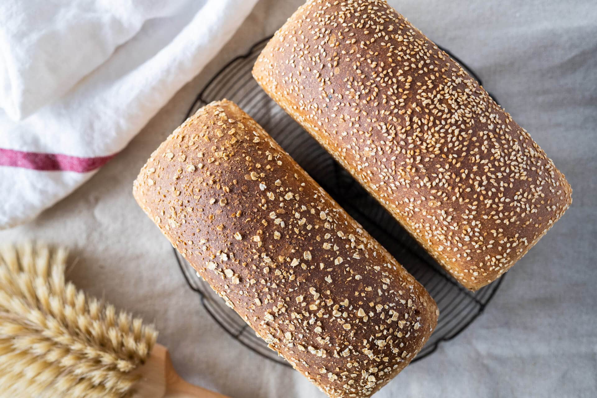 Sourdough sandwich bread with pre-cooked flour crust topped with oats and white sesame
