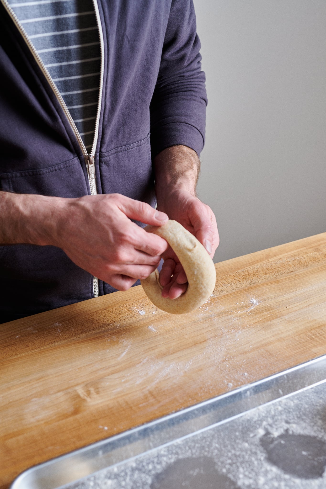 Stretch the sourdough friselle dough to make the ring larger.