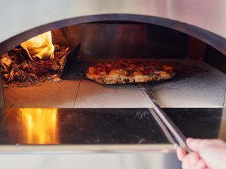 Cooking sourdough pizza in a wood-fired oven